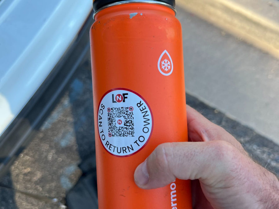 Orange water bottle with a Lost N Found scan-to-return tag