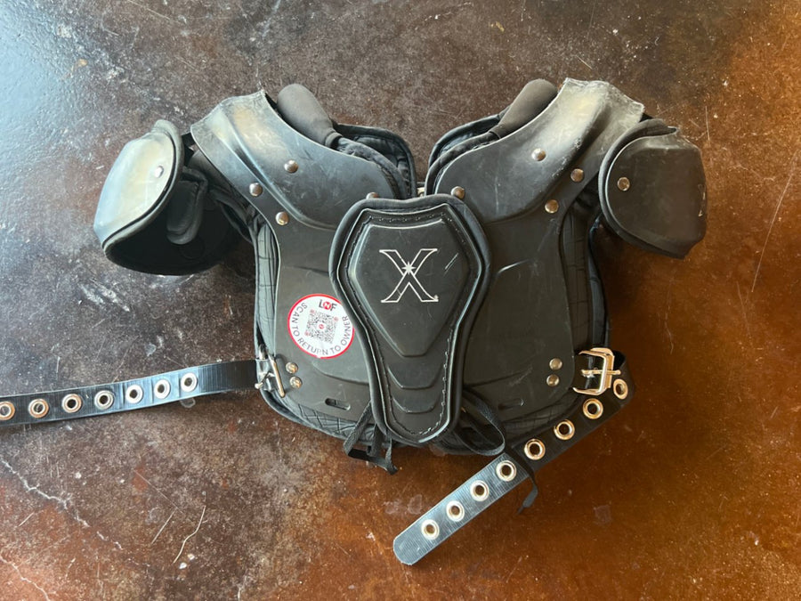 Youth football shoulder pads with a Lost N Found QR return tag