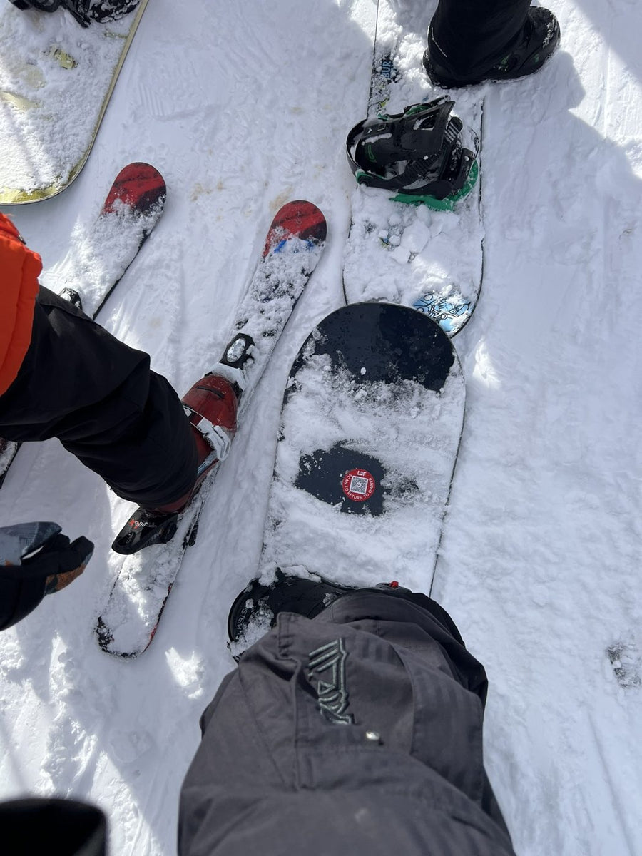 A snowboard top sheet with a round Lost N Found QR return tag near the tail